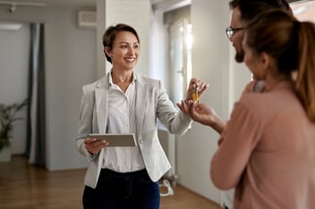 Female landlord giving the keys to her property to her first tenants