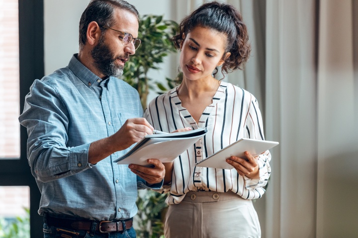 Male and female real estate investors reviewing lease terms